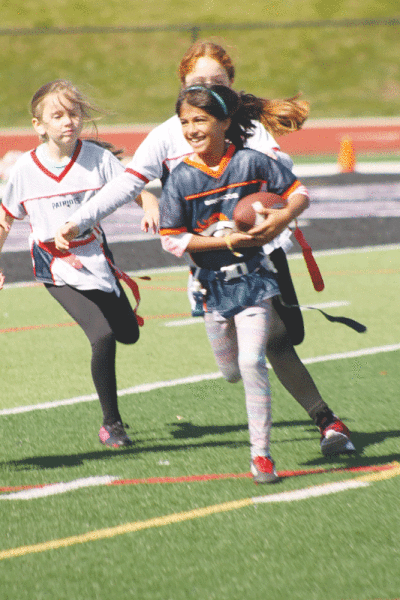  A Broncos ball-carrier is all smiles as she attempts to find the endzone. 