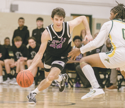  Bloomfield Hills senior guard Noah Adamczyk drives past a Groves defender. 