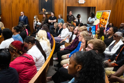 Printed photographs of Tai’Raz Moore, 6, stand in the back of a packed courtroom during the sentencing hearing for Nicholas Bahri June 29. 