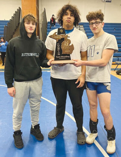  From left, St. Clair Shores Lakeview wrestling seniors Matt Horak, Sean Bias and Joseph Trupiano hold the district championship title the team brought home on Feb. 9 at Lakeview High School. 