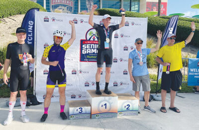  Alain Faleix is photographed by the podium with the top finishers in a cycling event at the National Senior Games in Fort Lauderdale, Florida, last month. 