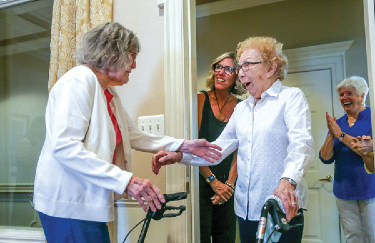  Joy Klomp, left, surprises her sister, Carol Timmer, at Waltonwood Twelve Oaks June 21. Klomp, who lives in California, and Timmer, who lives at the Novi senior living facility, had not seen each other in five years. 