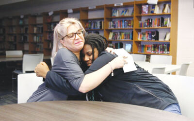  Roseville Middle School seventh grader A’Myrah DeBose, right, gets a hug from art teacher Jen Moore. 