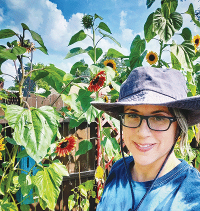  Sandoval, seen here tending to sunflowers in 2021, said native gardens require less water and no pesticides or herbicides, making them healthier  for the environment.  
