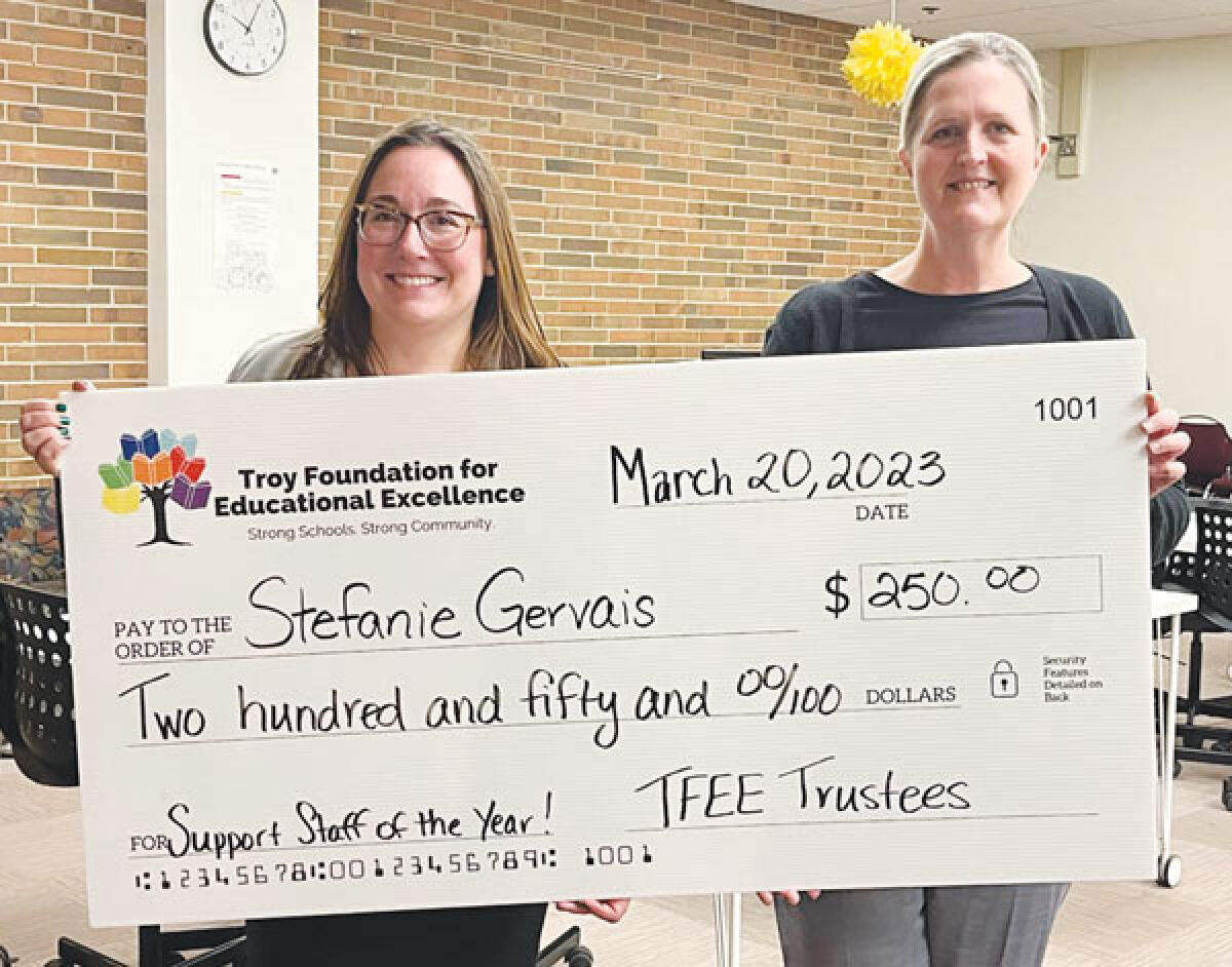 Alison Hendry, the executive director of the Troy Foundation for Educational Excellence, left, presents Stephanie Gervais, right, with a check for $250 after Gervais was named the Troy School District’s support staff member of the year. 