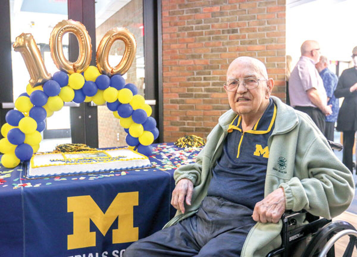  Wilbur Bigelow poses for a photograph with his cake and decorations at his surprise 100th birthday party in Ann Arbor March 16. Bigelow taught at the University of Michigan for 40 years before his retirement in 1993, and he continued with the university as a consultant into his 90s. 