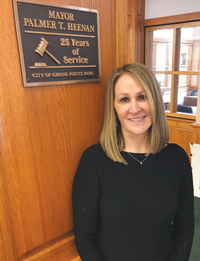  Retiring Grosse Pointe Park Finance Director/Treasurer/City Clerk Jane Blahut stands next to a plaque that marked late former Mayor Palmer Heenan’s 25th anniversary in office. Heenan was one of the mayors Blahut worked with closely during her long tenure with the city. 