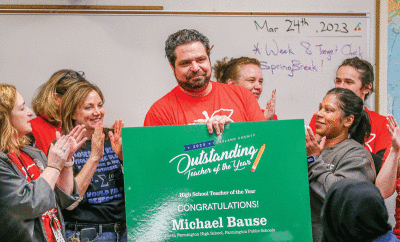  North Farmington High School science teacher Michael Bause is surrounded and applauded by his fellow science teachers following the announcement that he had been named the Oakland County Outstanding High School Teacher of the Year March 24.  