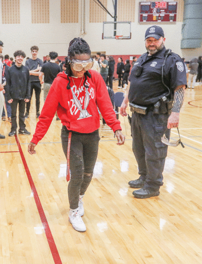  During the mock traffic stop, freshman Leajah Ferguson, with school resource officer Darryl Bagiano,  tried to walk a straight line with goggles that distort vision. 