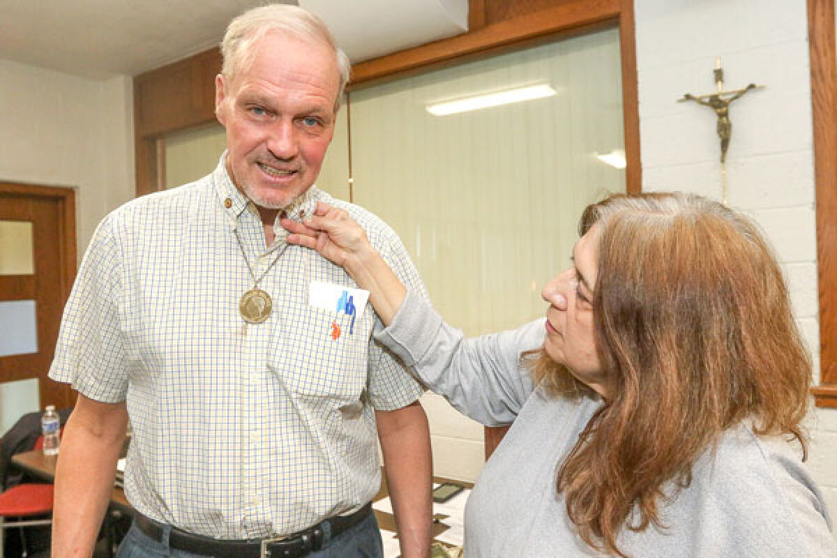  Linda Accettola, of Warren, secures the 50-year Knights of Columbus pin on Eastpointe resident James Shanahan’s collar. His dad, grandfather and uncle were all active in the charitable organization. 