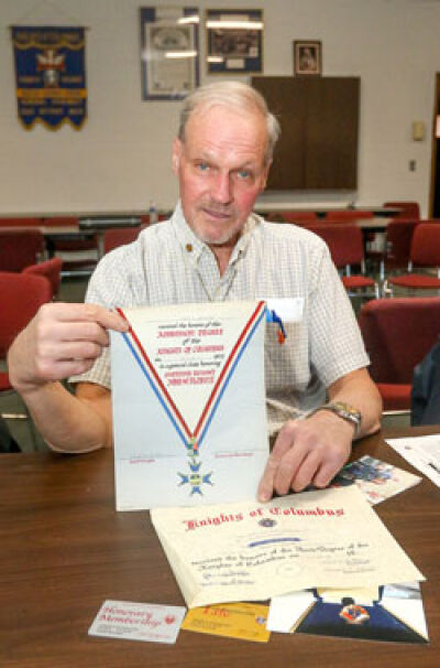  Shanahan holds up documents that date back to 1972, when he first joined the Knights of Columbus. 