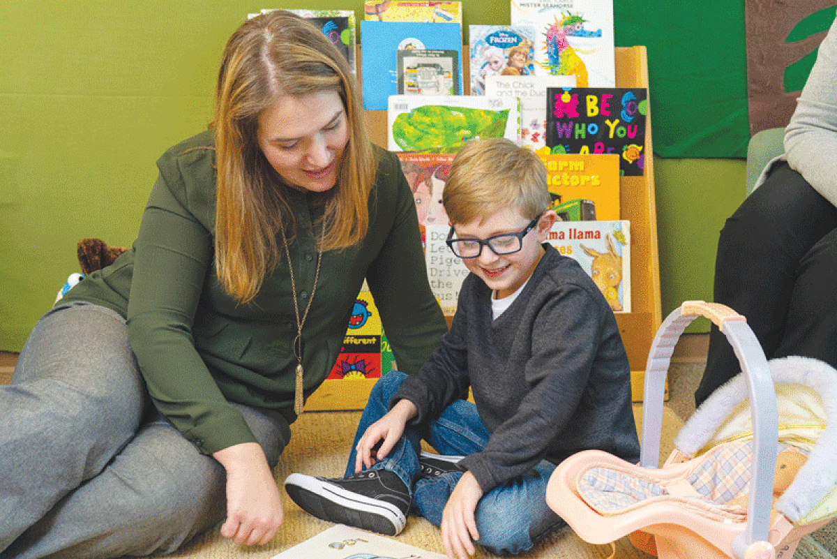  Kristin Rohrbeck, the director of OUCARES, works with a child in the Center for Autism at Oakland University. 