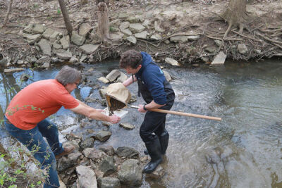  Steve Boegehold, of Clinton Township, joins in on the hunt with team leader Ben Kramer, of Ann Arbor, to collect water samples from the Rouge River in Southfield. 