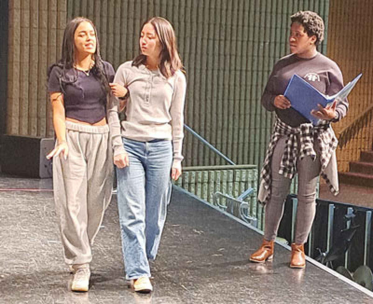  Ava Moretto, portraying Ursula, and Hannah Jeong, portraying Ariel, rehearse a scene from “The Little Mermaid” with student director and stage manager Nicole Watts at the Novi High School auditorium April 7. 