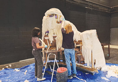  Set designer Purani Murukathas and Alexander Dyga, who plays Sir Grimsby, construct a paper-mache prop. 