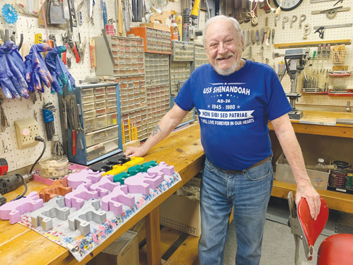  Don Paulus stands in his workshop with painted toys he’s been working on. 