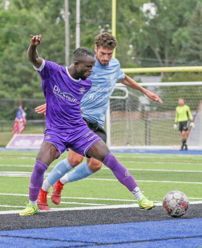  Malvin Gblah battles for control of the ball against a Kalamazoo FC player last July. Gblah is returning to Oakland County FC this season. 