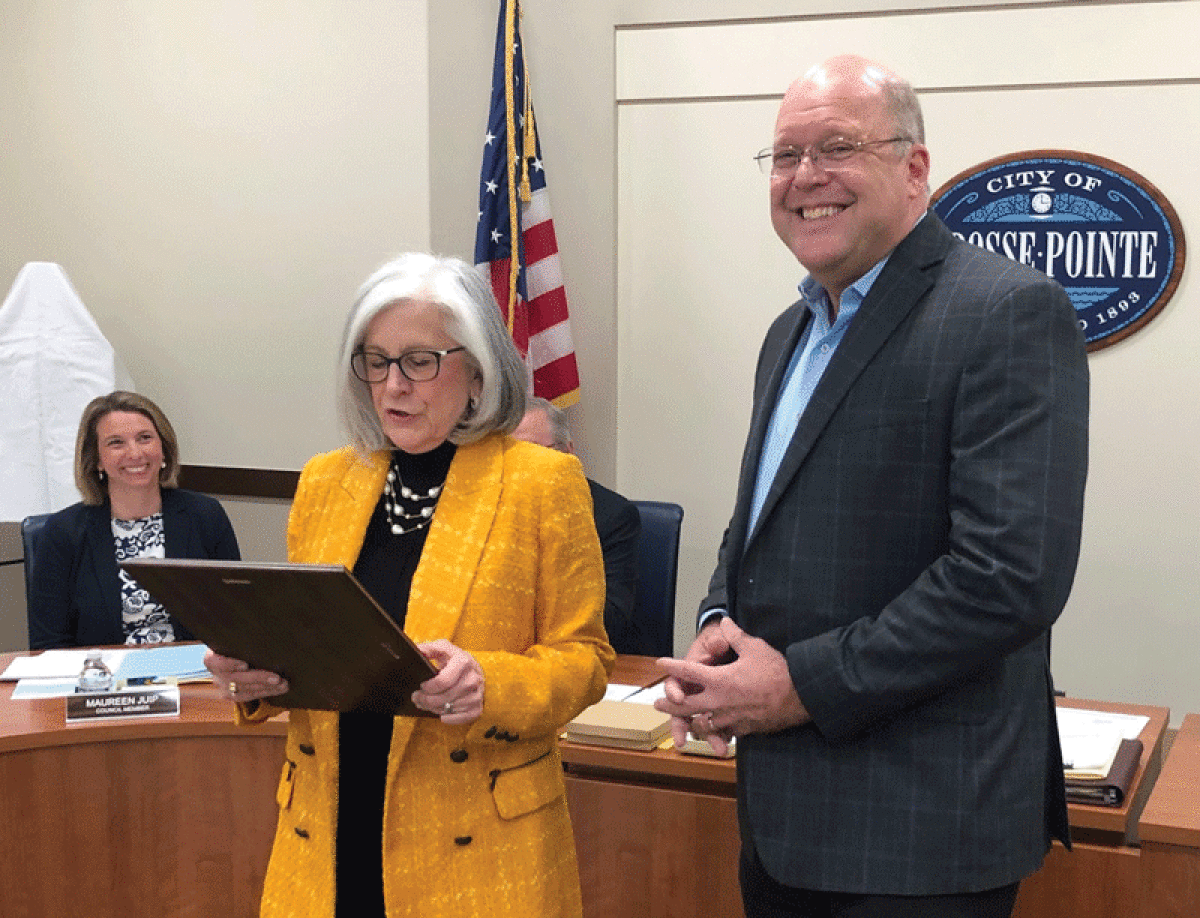  Grosse Pointe City Manager Pete Dame, right, smiles as Mayor Sheila Tomkowiak reads a resolution in Dame’s honor at the April 17 City Council meeting.  