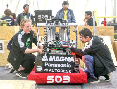  Novi High School seniors Lexi Maxton, left, and Julia Araujo, right, make adjustments to the Frog Force robot during a practice session April 16. 