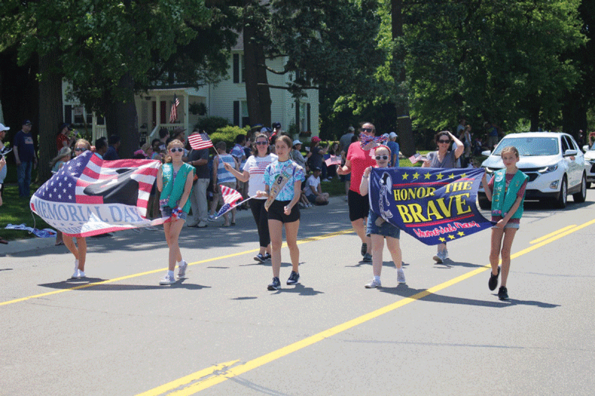  Girls Scouts march down Adams Road during a past Memorial Day Parade of Heroes. 