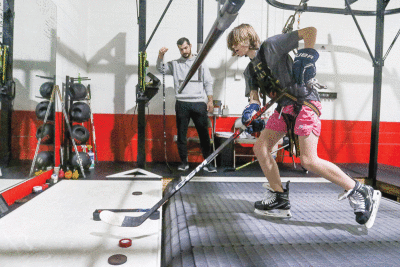  Jake Ruth, 12, works on his skating stride on the treadmill while Synergy SPT trainer Matt Thomas observes. 