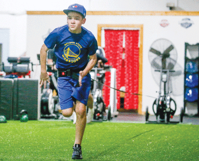   Xander Clancy, 12, uses the run rocket to add resistance to his sprint.  