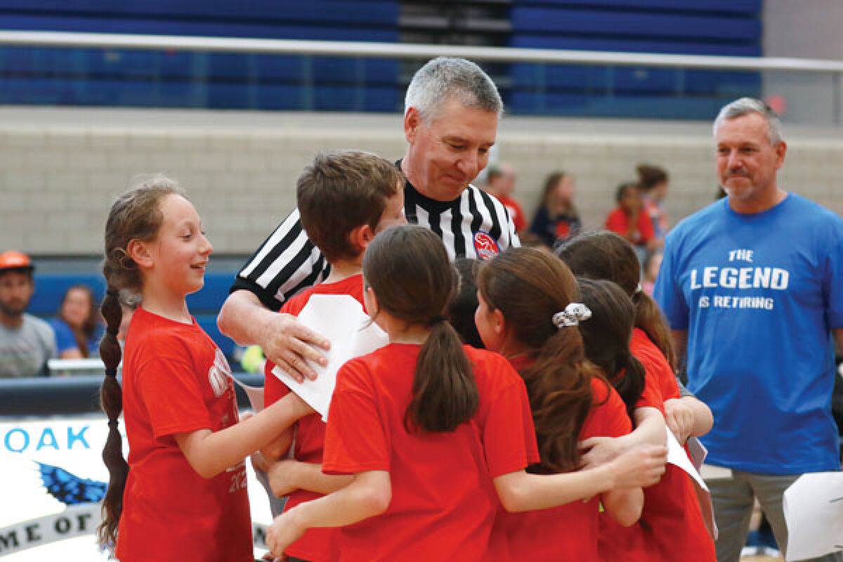  Retiring physical education teacher Mike Lewis gets a group hug from some of his students April 28 at Royal Oak High School. 