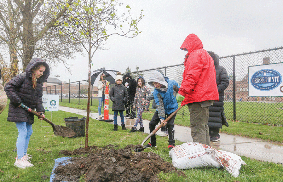  Maire Elementary School second graders and Green Team members Joanna Vasquez and James Mason cover the roots of the tree with dirt during the Arbor Day planting. 