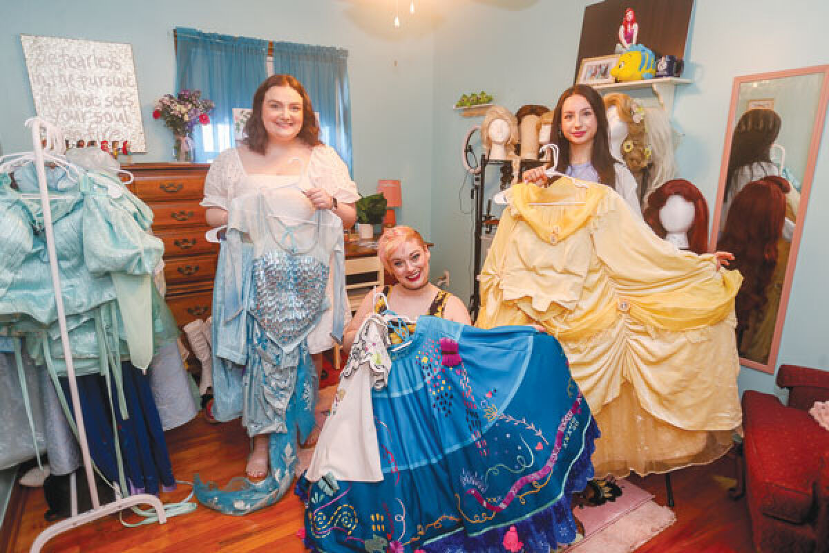  From left, Sofia Kirkman, Teresa Roman and Mia Mattaliano hold a few of the princess costumes the cast uses for their performances.  