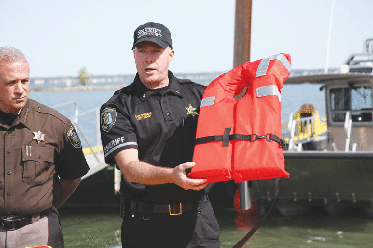  Lt. Gary Wiegand, of the Macomb County Sheriff’s Office Marine Division, shows off a Type II life jacket at a boating safety press conference on May 25. Type I and Type II life jackets must be present on the boat while Type V jackets must be worn at all times on a boat. 