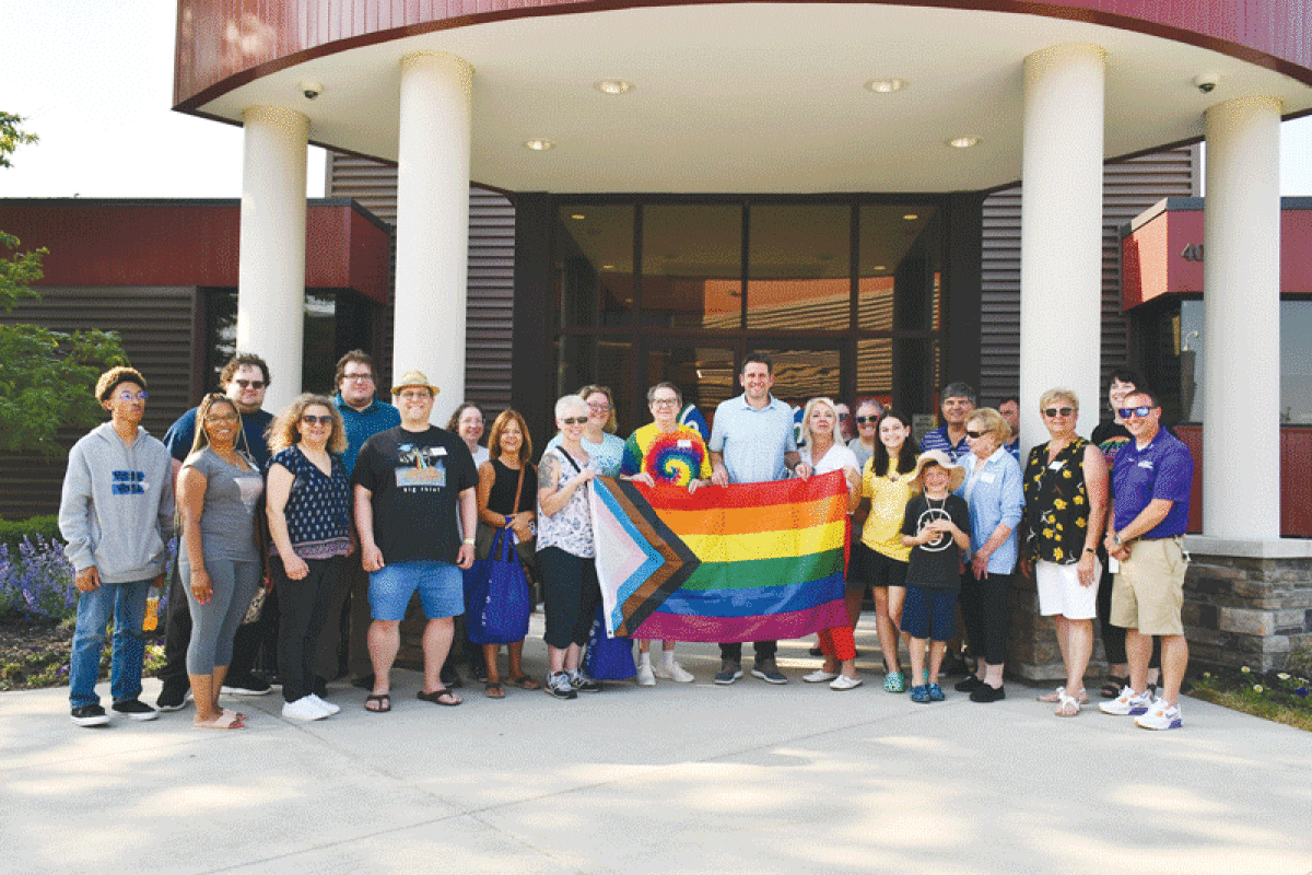  Sterling Heights city officials and community members pose with a Pride flag by City Hall on June 1 during a flag raising ceremony.  