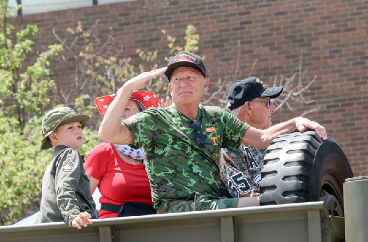  Campbell Fox, 8, of Grosse Pointe Park, rides in the parade with his grandfather, Roger Fox, 77, of Roseville, center, and Mick DeKeyser, right. Both Roger Fox and DeKeyser are Vietnam veterans. 