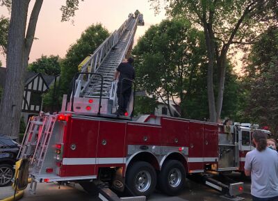  One of the two ladder trucks on the scene attempts to battle the Lincoln Road house fire from above. 