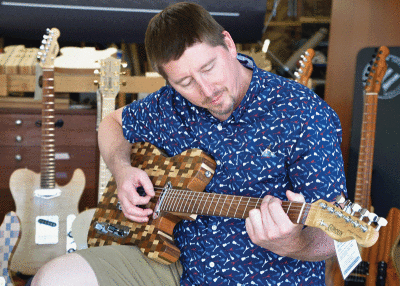 Paul Giroux strums a guitar that will be up for sale at the Berkley Art Bash. The Berkley Art Bash will be the first event that Giroux has participated in to sell his guitars. 