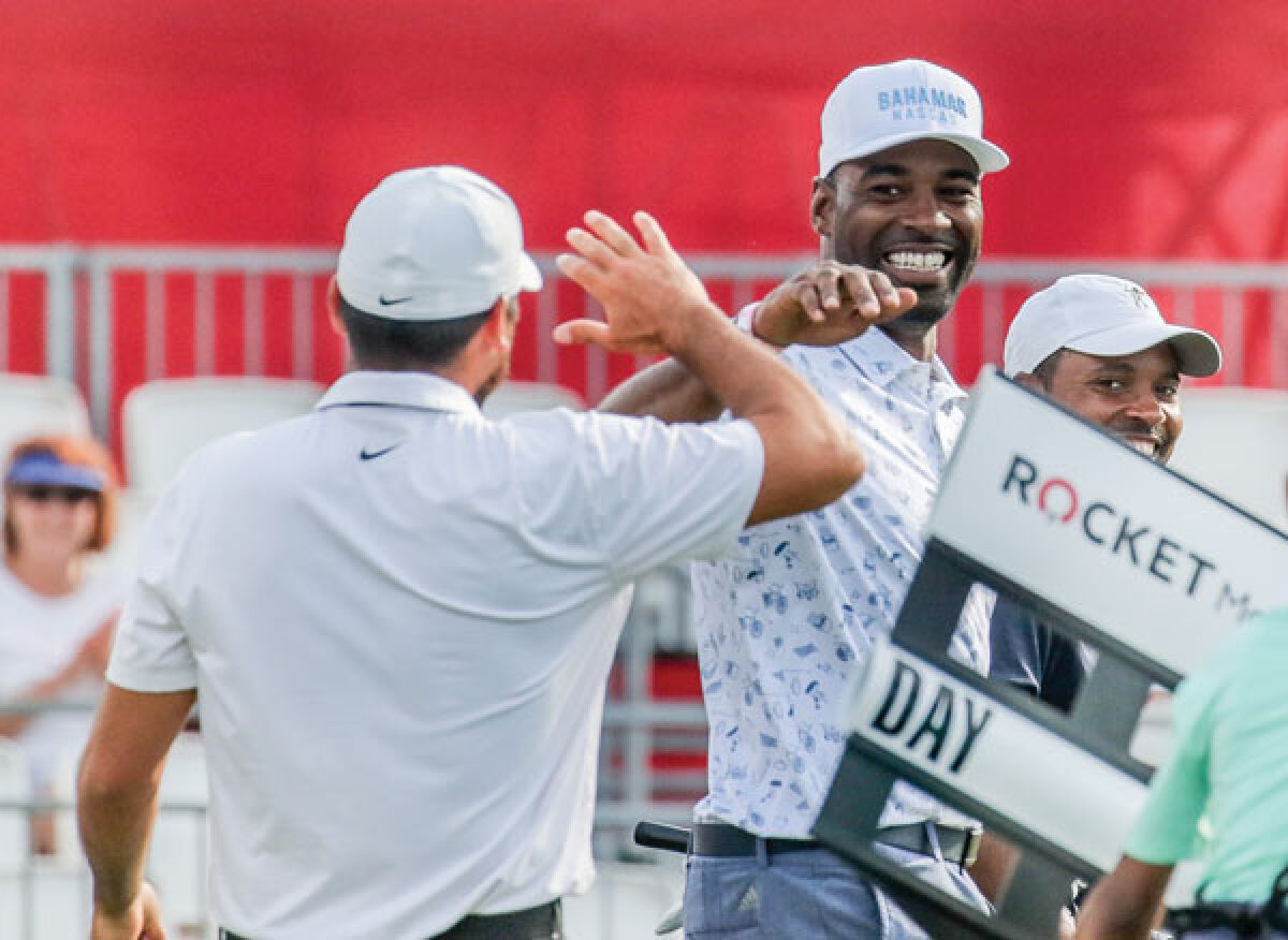  NFL Hall of Famer Calvin Johnson high-fives professional golfer Jason Day after Johnson drilled a 30-foot putt on the group’s final hole at last year’s event. 