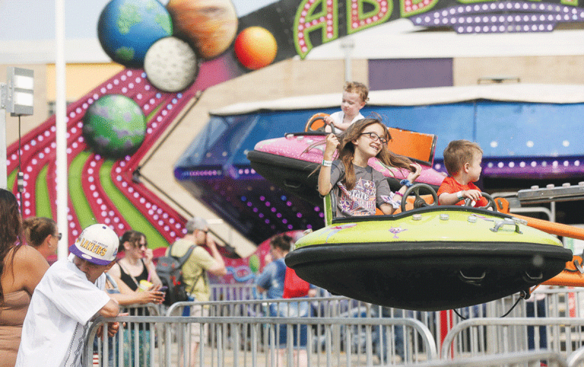 Kids enjoy the “Space Chase” ride at the carnival in the parking lot on the afternoon of June 4.  