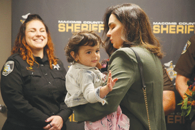  Mira Lateef waves to the audience during a reunion with first responders at the Macomb County Jail on June 8. Mira was rescued by Macomb County Sheriff’s Office deputies and Macomb Township Fire Department personnel after nearly drowning in an above-ground pool at home on June 3.  