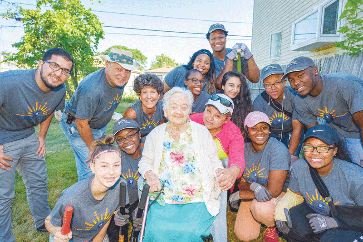  A team of volunteers from Interfaith Volunteer Caregivers poses with a woman whose yard they cleaned up. 