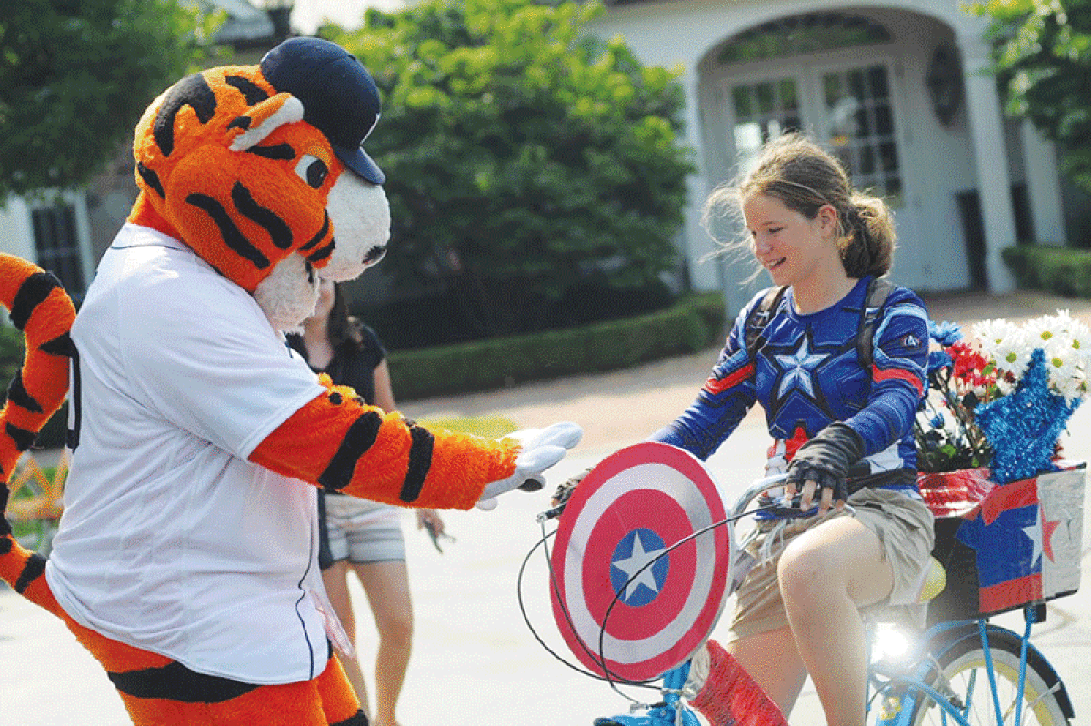  In this photo from 2018, Detroit Tigers mascot Paws greets a participant in the Grosse Pointe Farms Boat Club Regatta weekend’s decorated bike parade contest. The bike parade and other popular Regatta activities are on the schedule again for this year’s event, June 30 through July 2 at Pier Park. 