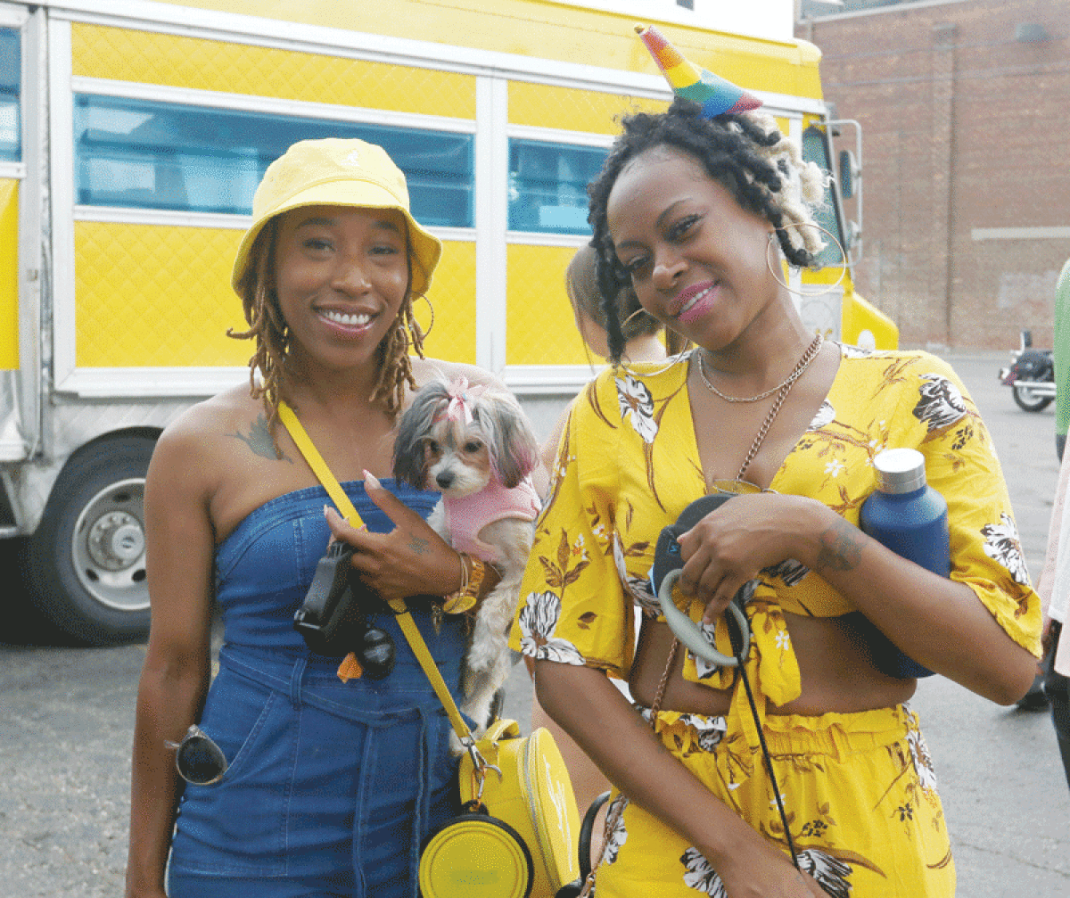  Along with her morkie, Dutchess, Pamela Serell, of Southfield, and Ty Lancaster, of Illinois, enjoy the Berkley Pride Block Party last year. 