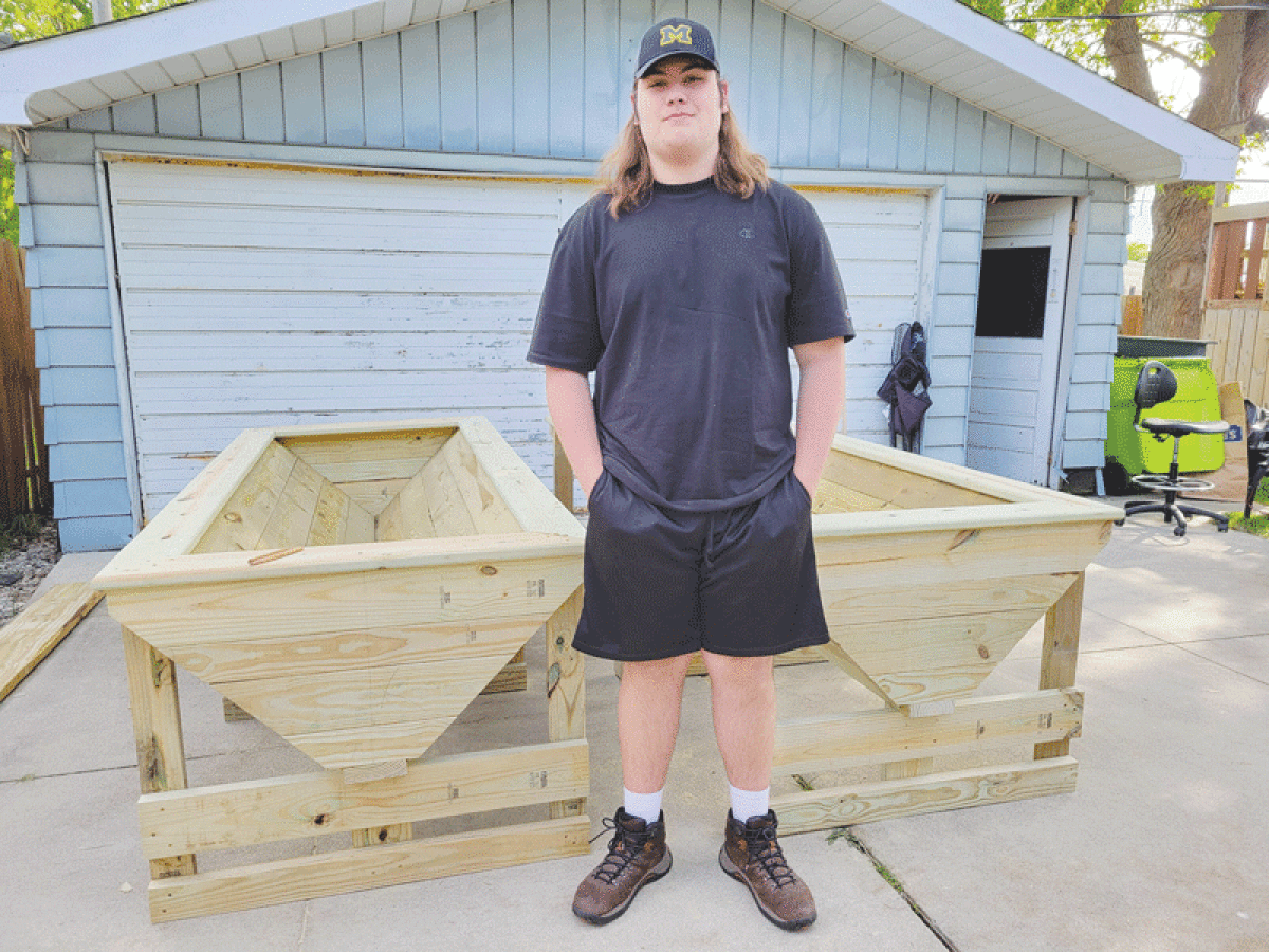  Harrison Township Scout Milan Edwards stands with two planters built as part of his Eagle Scout project. Edwards and other Troop 1407 Scouts built standing flower planters, swivel-back benches, wall planters and a sign for the Harrison Township Senior Center garden. 