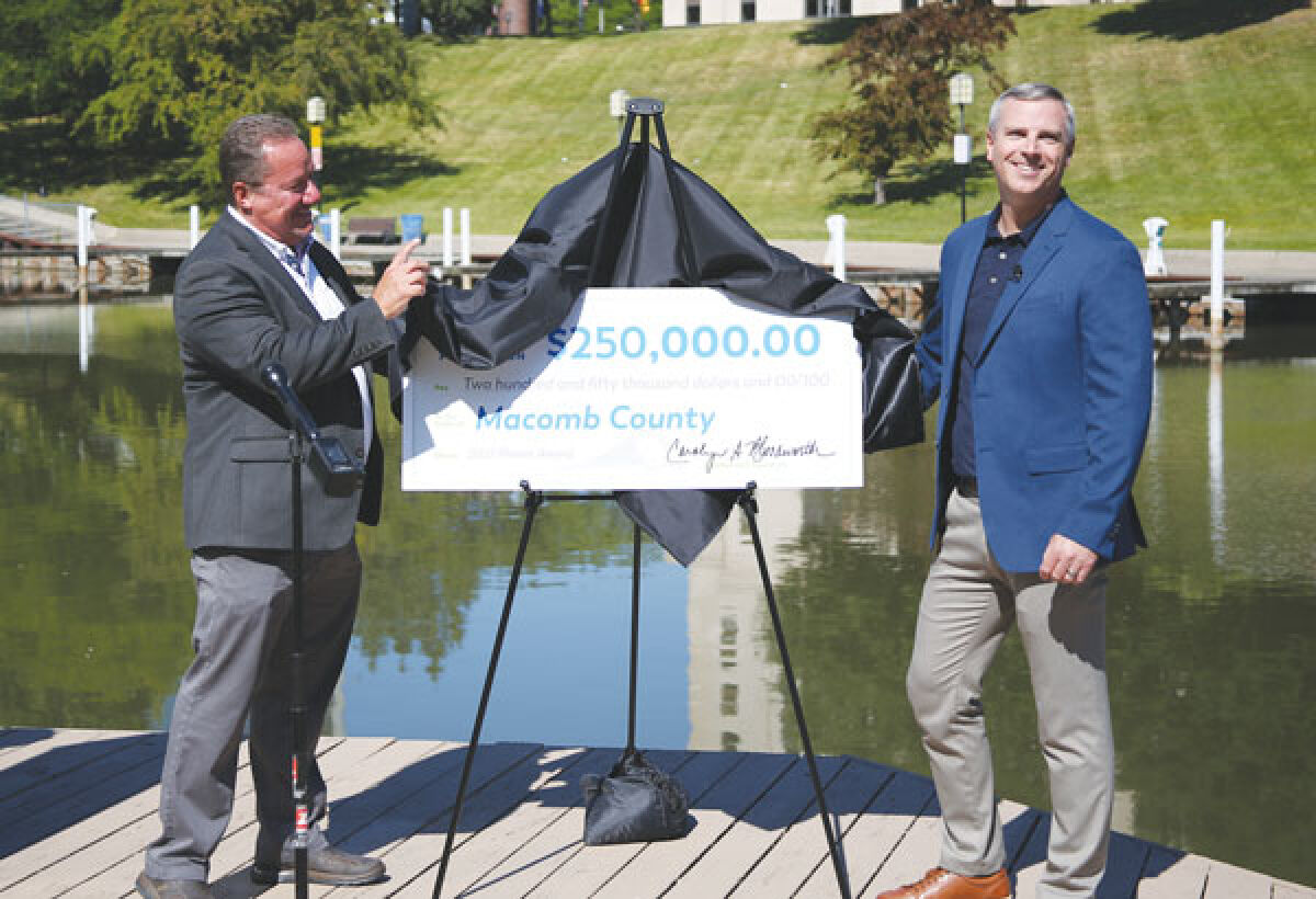  Various Macomb County, Consumers Energy and Mount Clemens officials pose with a $250,000 check to the Green Macomb Urban Forest Partnership in Mount Clemens on June 28. 