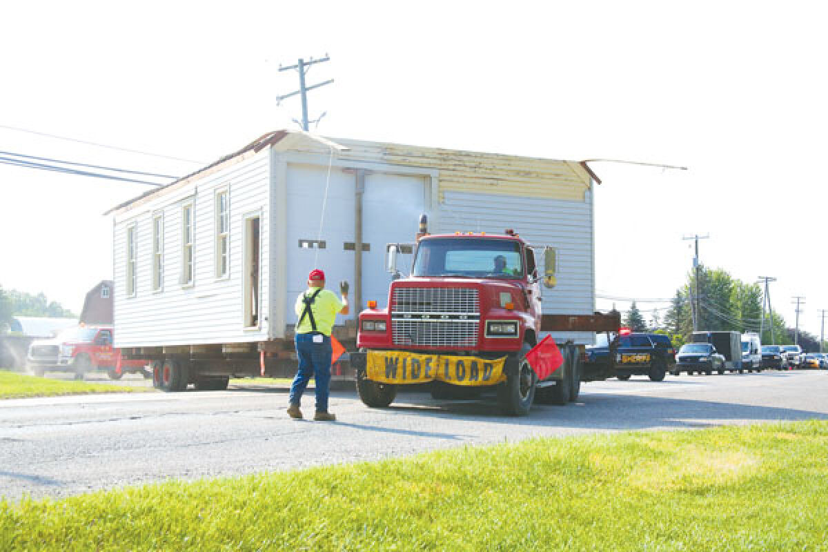  Fred Christian, president of C&A Building Movers, guides the old Macomb Township Hall off the former Wade Nursery property on the morning of June 21. 