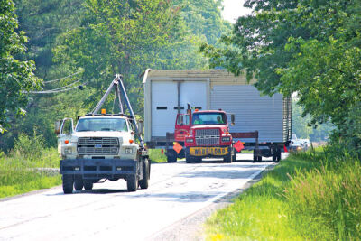  A C&A Building Movers truck pulls the old Macomb Township Hall down 25 Mile Road west toward the township municipal complex on June 21. 