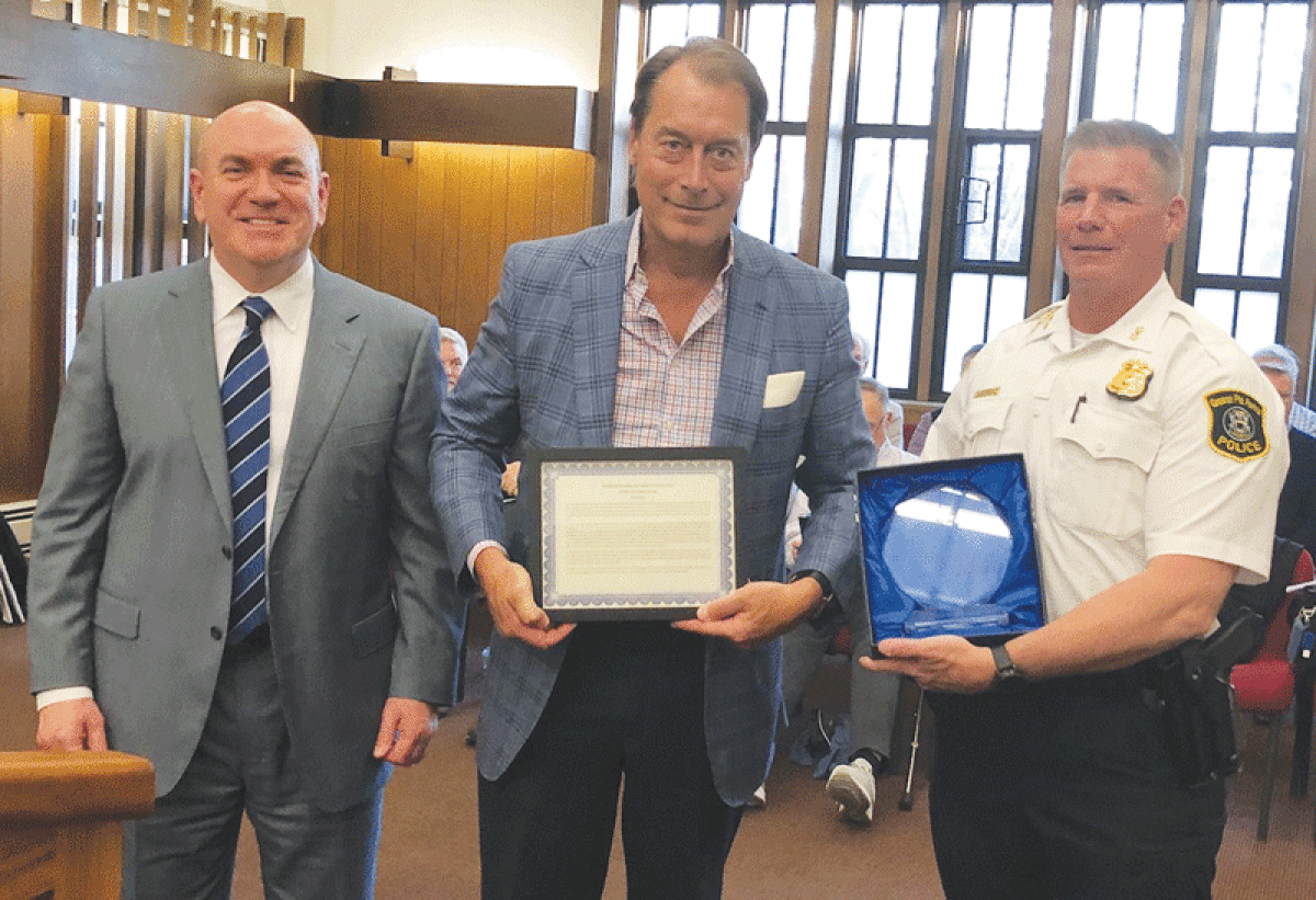  Grosse Pointe Farms resident Edward Russell, a developer and philanthropist, center, is honored by Grosse Pointe Farms Public Safety Director John Hutchins, left, and Farms Deputy Public Safety Director Andrew Rogers, right, for his support of the department’s K-9 program and other initiatives. 