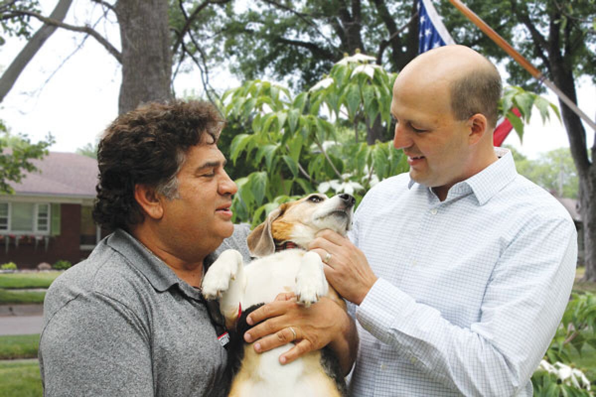  Councilman Dave Rubello, left, holds Teddy the dog with Michigan state Sen. Kevin Hertel. 