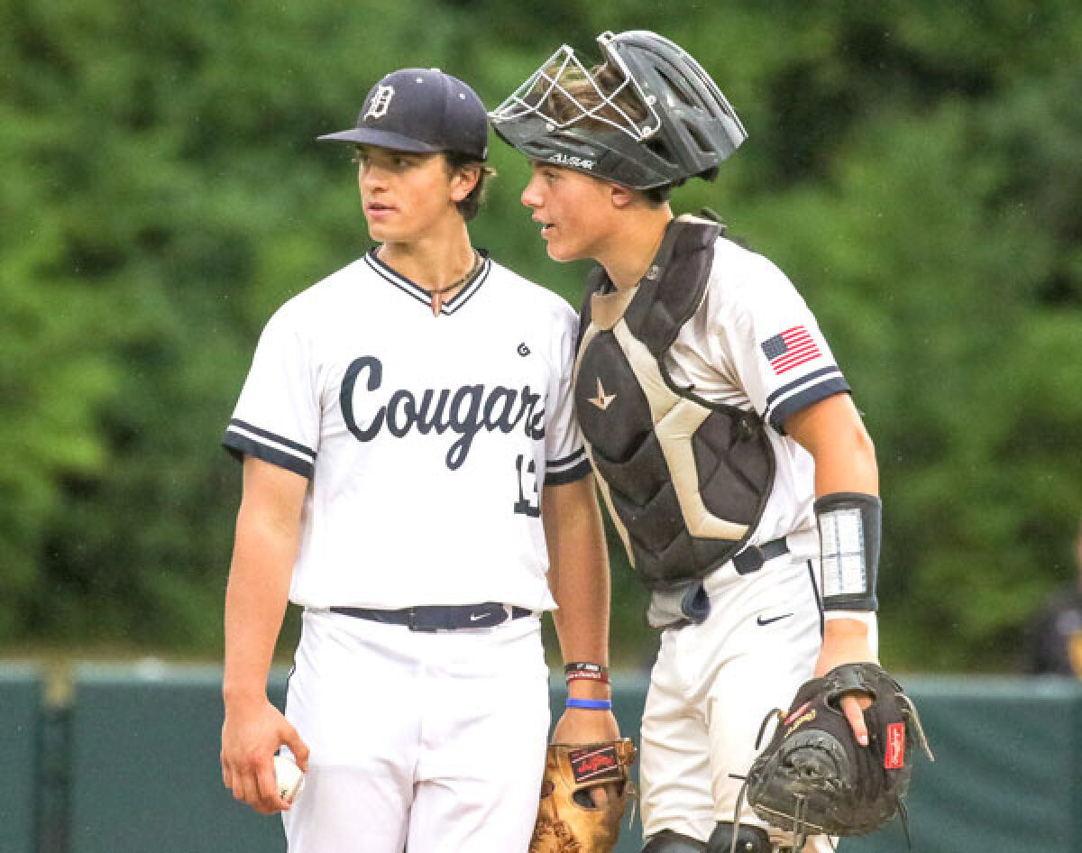  Macomb Dakota seniors Will DeMasse, left, and Alex Kavalick, right, have a conversation at the mound during the Michigan High School Athletic Association Division 1 semifinals on June 15 at Michigan State University. 
