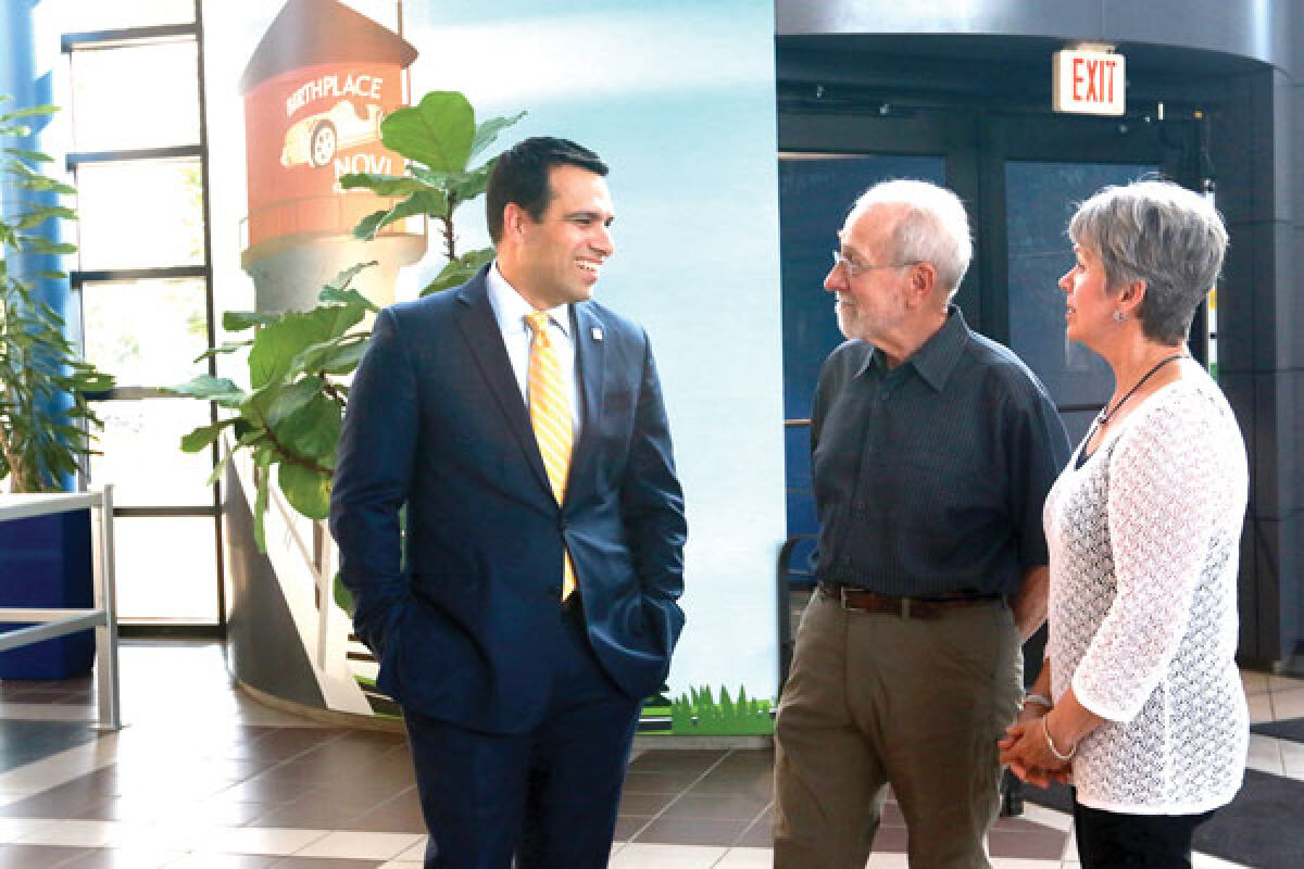  Novi’s new city manager, Victor Cardenas, left, talks with Novi residents Fil and Pam Superfisky during a welcome reception for Cardenas at the Novi Civic Center July 10 prior to the City Council meeting that evening. 