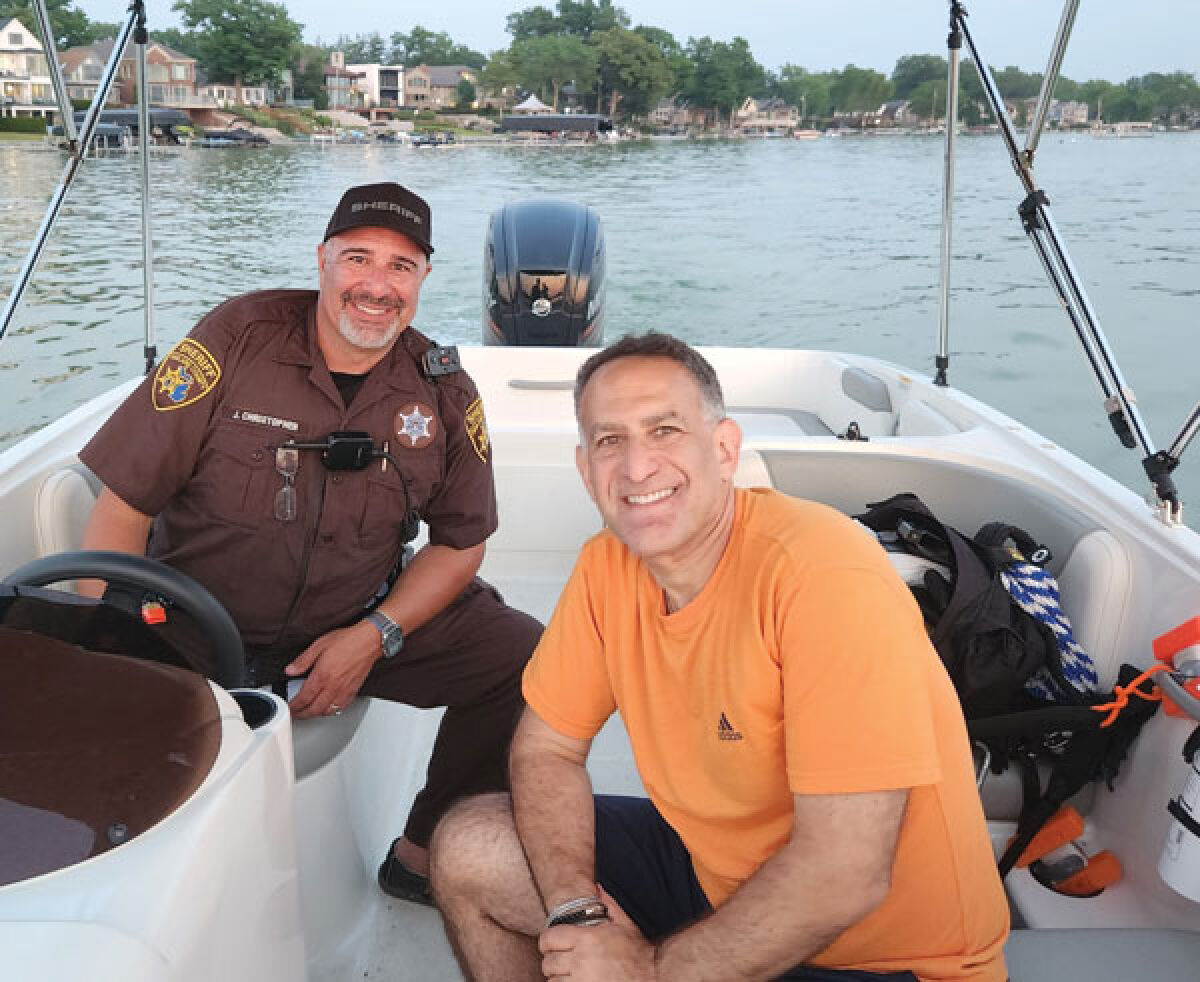  Keego Harbor Mayor Rob Kalman, right, is pictured with a member of the Oakland County Sheriff’s Office. Kalman recently announced a grant that will help pay for safety on Cass Lake. 