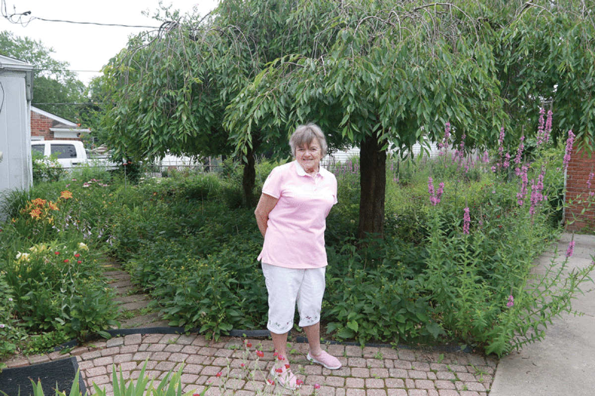   Barbara Baty stands in the backyard of her old house in Mount Clemens where she and Don Bety built one of the city’s best gardens. 
